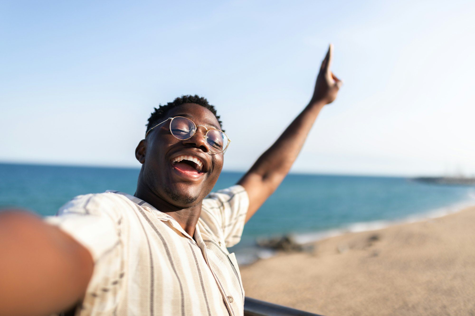 African American man take selfie at the beach during vacations. Happy, black male looking at camera.